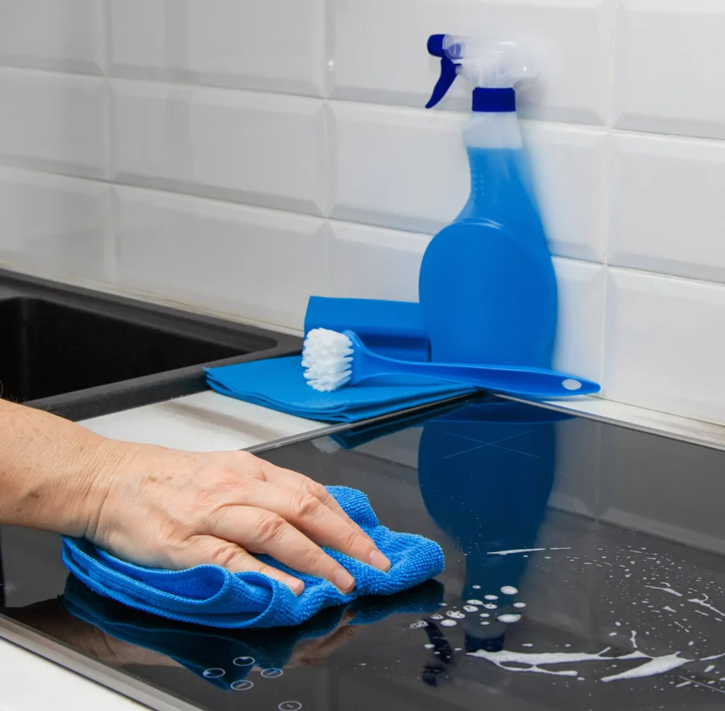 man cleaning oven with blue cloth