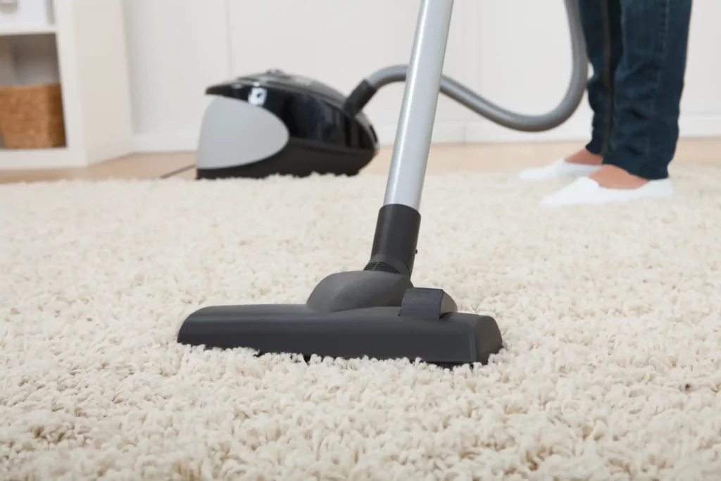 close up view of vacuum cleaning white rug
