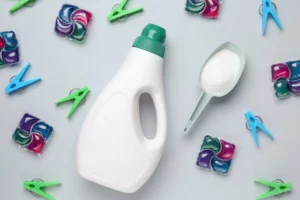 powder vs liquid detergent. Pods and washing pegs around the powder detergent and liquid detergent