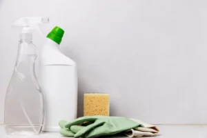 zero waste cleaning supplies, reusable trigger sprays and bottles with sponge and green gloves on the side